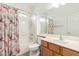 Cozy bathroom with shower-tub combo and vanity with a decorative curtain at 43945 W Juniper Ave, Maricopa, AZ 85138