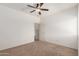 A bedroom with neutral carpet, ceiling fan, and a large window at 43945 W Juniper Ave, Maricopa, AZ 85138