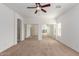 Bright bedroom with ceiling fan, carpeted floors, and mirrored closet doors at 43945 W Juniper Ave, Maricopa, AZ 85138