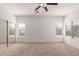 Bright bedroom with ceiling fan, carpeted floors, and mirrored closet doors at 43945 W Juniper Ave, Maricopa, AZ 85138