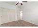 Bedroom with neutral carpet, a ceiling fan, and double-door closet at 43945 W Juniper Ave, Maricopa, AZ 85138