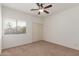 Comfortable bedroom with a ceiling fan, window and neutral carpet at 43945 W Juniper Ave, Maricopa, AZ 85138