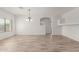 Open dining area with wood-look flooring, chandelier, and a view into the next room at 43945 W Juniper Ave, Maricopa, AZ 85138