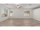 Spacious living room with wood-look flooring, ceiling fan, and plenty of natural light at 43945 W Juniper Ave, Maricopa, AZ 85138