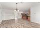 Spacious living room with wood-look tile flooring open to the kitchen at 43945 W Juniper Ave, Maricopa, AZ 85138