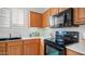 A modern kitchen with wooden cabinetry and black appliances at 4831 E Annette Dr, Scottsdale, AZ 85254