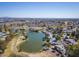 Wide aerial shot displaying the neighborhood's houses, community pond, and golf course at 4843 E Ajo Cir, Phoenix, AZ 85044