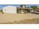 View of the home's back exterior, featuring a covered patio, rock accents, and desert landscaping at 4843 E Ajo Cir, Phoenix, AZ 85044