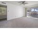 Neutral bedroom with ceiling fan, connecting door, and sliding glass doors with golf course views at 4843 E Ajo Cir, Phoenix, AZ 85044