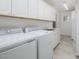 Functional laundry room with white cabinets, sink, and modern washer and dryer at 4843 E Ajo Cir, Phoenix, AZ 85044