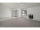 Open-concept living space with neutral carpet, a fireplace, and a sliding glass door at 4843 E Ajo Cir, Phoenix, AZ 85044