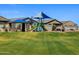 Neighborhood park featuring a covered picnic pavilion, green grass and a blue and green playground at 4848 W Hunter Trl, San Tan Valley, AZ 85144