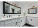 Modern bathroom with double sink vanity, dark hardware, and framed mirrors with bright vanity lighting at 4950 N Miller Rd # 119, Scottsdale, AZ 85251