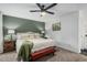 Comfortable bedroom with a sage green accent wall, ceiling fan and rustic wood bedside tables at 4950 N Miller Rd # 119, Scottsdale, AZ 85251