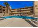 Community swimming pool surrounded by a decorative fence, lounge chairs, and well-kept landscaping at 4950 N Miller Rd # 119, Scottsdale, AZ 85251