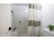 Bright white bathroom featuring a tiled shower-tub combo and decor on inset shelves at 5223 N 24Th St # 108, Phoenix, AZ 85016