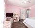 Pretty pink bedroom featuring a cozy bed, closet access, and modern shelving unit at 5223 W Lewis Ave, Phoenix, AZ 85035