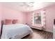 Charming pink bedroom featuring a cozy bed, bench, and soft natural light from the window at 5223 W Lewis Ave, Phoenix, AZ 85035