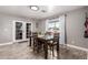 Bright dining area with wood-look tile floors and natural light from large windows at 5223 W Lewis Ave, Phoenix, AZ 85035