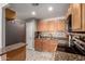 Updated kitchen featuring warm wood cabinets, granite countertops, and stainless steel appliances at 5223 W Lewis Ave, Phoenix, AZ 85035