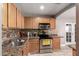 Well-lit kitchen featuring wood cabinets, granite countertops, and stainless steel appliances at 5223 W Lewis Ave, Phoenix, AZ 85035