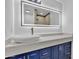 Bathroom featuring modern sink, quartz countertop, blue vanity, and LED mirror at 5942 W Seldon Ln, Glendale, AZ 85302