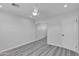 Bright bedroom featuring light gray plank flooring, a ceiling fan, and sliding closet doors, offering ample storage at 5942 W Seldon Ln, Glendale, AZ 85302