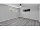 Bedroom with light gray walls, light wood floors, a ceiling fan and two windows at 5942 W Seldon Ln, Glendale, AZ 85302