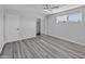 This bedroom features light gray walls, light wood floors, a ceiling fan, closet, and a window at 5942 W Seldon Ln, Glendale, AZ 85302