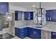 Close-up of remodeled kitchen showcasing blue cabinets, crystal pendant lighting, and stainless steel appliances at 5942 W Seldon Ln, Glendale, AZ 85302