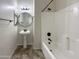 Well-lit bathroom with a tub/shower combo, pedestal sink, and neutral tile flooring at 6202 E Mckellips Rd # 227, Mesa, AZ 85215