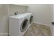 Spacious laundry room equipped with white front load washer and dryer on light tile flooring at 6202 E Mckellips Rd # 227, Mesa, AZ 85215