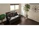 View of a dark brown leather sofa with hardwood floors and a view of a window at 7500 E Deer Valley Rd # 59, Scottsdale, AZ 85255