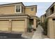 Two-story tan home features an attached two-car garage, desert landscaping, and a walkway to the front door at 7887 N 16Th St # 227, Phoenix, AZ 85020