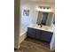 Bathroom featuring a soaking tub, wood flooring and a dual sink vanity at 8648 W Fargo Dr, Peoria, AZ 85382