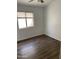 A cozy bedroom featuring wood floors, a ceiling fan, a window with blinds, and crisp white walls at 8648 W Fargo Dr, Peoria, AZ 85382