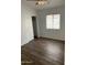 Bedroom with wood floors, sliding closet door, a window with blinds, and fresh white paint at 8648 W Fargo Dr, Peoria, AZ 85382