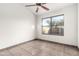 Empty bedroom features ceiling fan, tile floors, and large window at 8709 W Roanoke Ave, Phoenix, AZ 85037