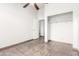 Empty bedroom features ceiling fan, tile floors, and closet at 8709 W Roanoke Ave, Phoenix, AZ 85037