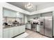 Bright kitchen features stainless steel appliances, light green cabinetry, and granite countertops at 8709 W Roanoke Ave, Phoenix, AZ 85037