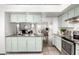 Kitchen view with stainless appliances, light green cabinetry and granite countertops at 8709 W Roanoke Ave, Phoenix, AZ 85037