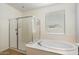 Beautiful primary bathroom featuring a soaking tub, frameless glass shower, and a window for plenty of natural light at 9010 W Ruth Ave, Peoria, AZ 85345