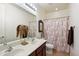 Bright bathroom featuring a double sink vanity with sleek fixtures and a patterned shower curtain at 9010 W Ruth Ave, Peoria, AZ 85345