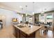 Open floor plan with kitchen island, stainless steel sink, pendant lighting, and adjacent dining and living areas at 9010 W Ruth Ave, Peoria, AZ 85345