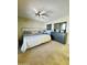 Cozy bedroom with neutral carpeting, ceiling fan, and a dark dresser with a mirror at 9231 W Elkhorn Dr, Sun City, AZ 85351