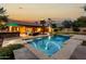Backyard featuring a pool, palms, and an outdoor kitchen at sunset at 10105 E Larkspur Dr, Scottsdale, AZ 85260