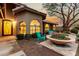 Close-up of the front entrance with a decorated front door, arched windows, and a charming outdoor seating area at 10105 E Larkspur Dr, Scottsdale, AZ 85260