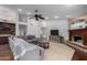 Open living room with fireplace, wooden floors, and a cozy sectional sofa under a vaulted ceiling at 10105 E Larkspur Dr, Scottsdale, AZ 85260