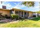 A backyard view with a screened-in porch area, complemented by a lush lawn and stepping stones at 11047 N Coggins Dr, Sun City, AZ 85351