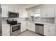 Modern kitchen featuring stainless steel appliances, white cabinets, and stylish backsplash at 11047 N Coggins Dr, Sun City, AZ 85351